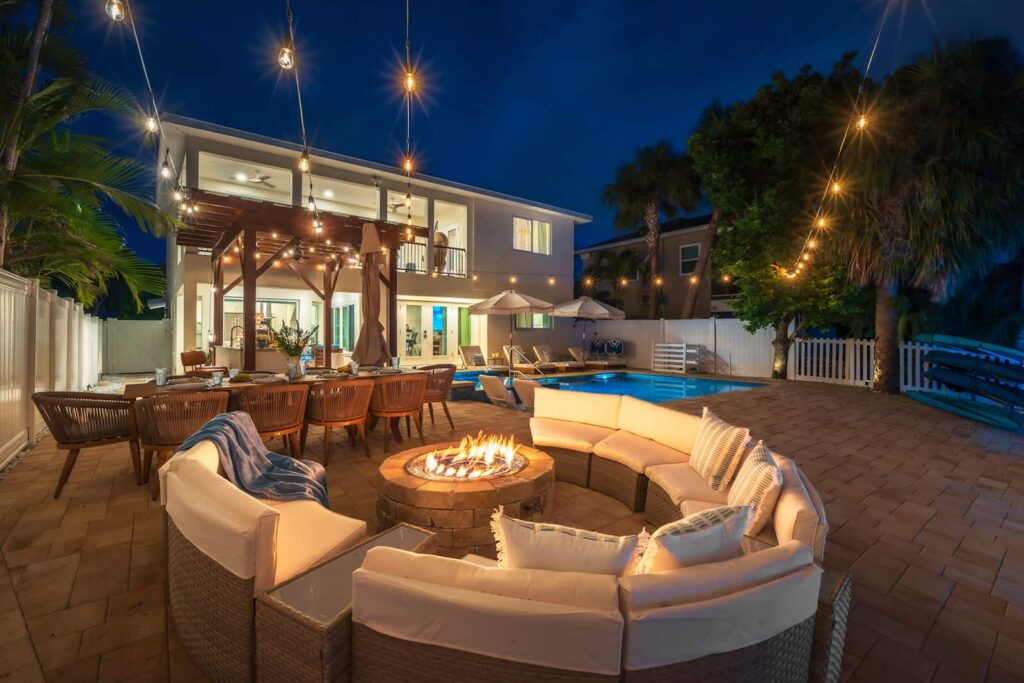 Patio with a fire pit and string lights at night at Casa Blue Horizon