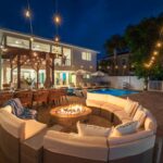 Patio with a fire pit and string lights at night at Casa Blue Horizon