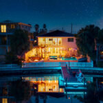 The home lit up at night across the water at Casa Blue Horizon